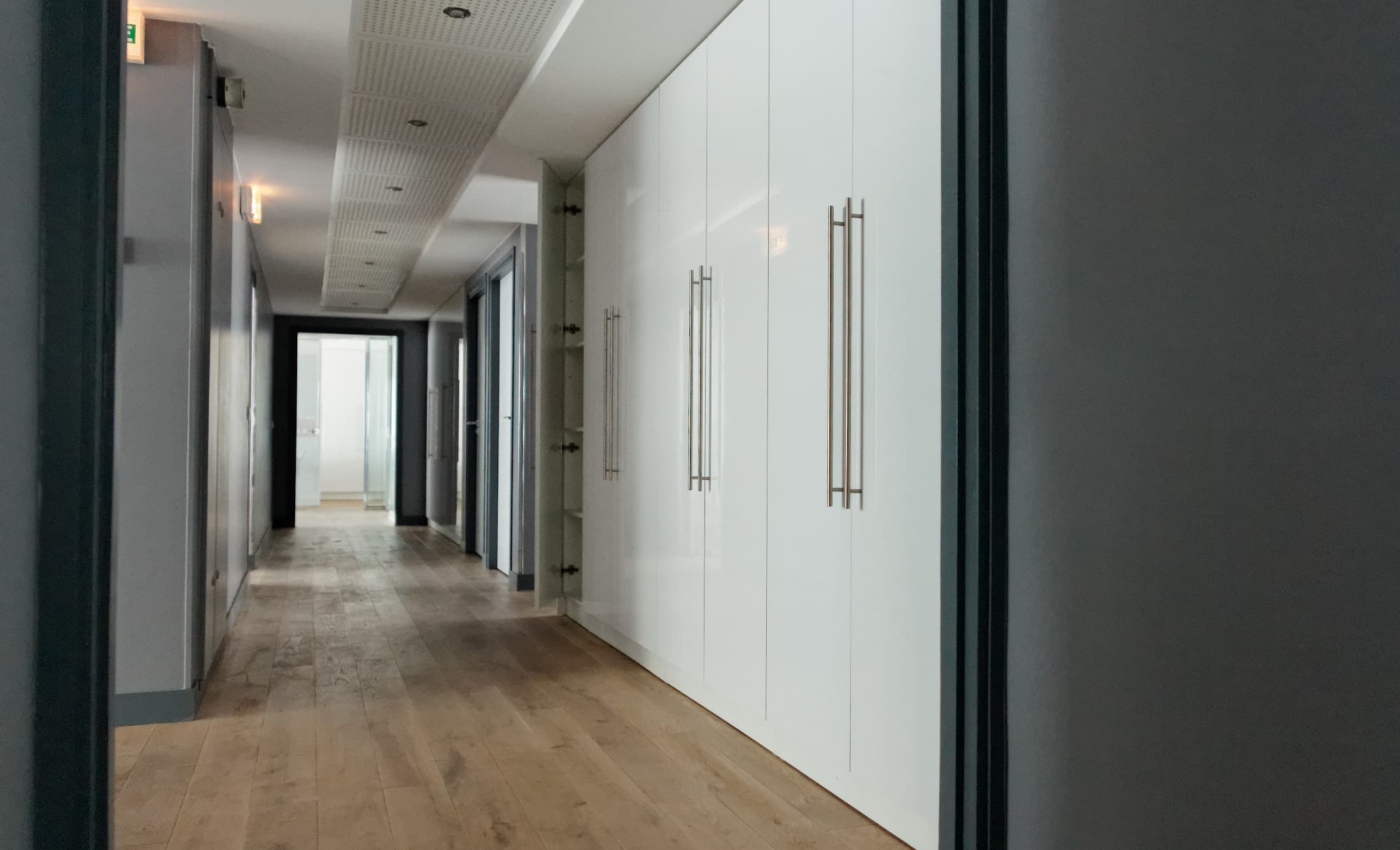 Rangements intégrés le long d’une circulation des bureaux CGE.